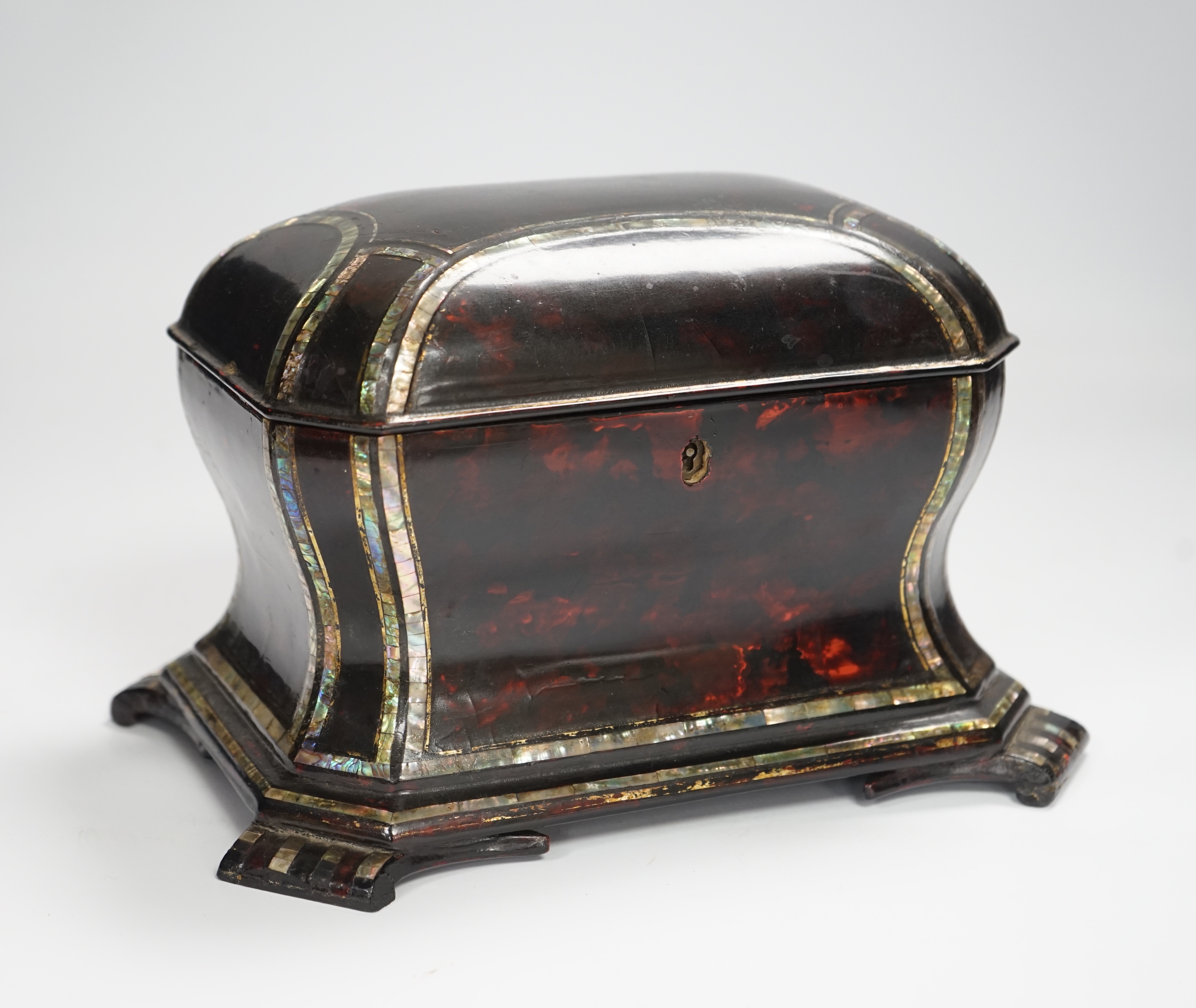 A Victorian papier mache tea caddy, stamped Jennens and Bettridge, in the form of a sarcophagus with inset mother of pearl banding, with two internal lidded compartments, 15cm high